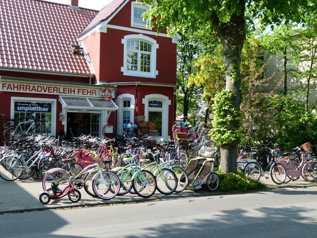 Verschiedene Fahrräder und Kinderanhänger vor dem Fahrradverleih Fehr auf Föhr